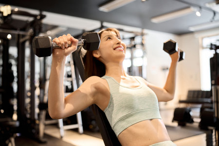 Woman training her chest with dumbbell pressesの写真素材