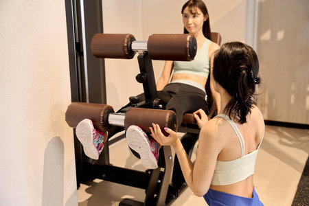 Woman training her legs with leg extensions