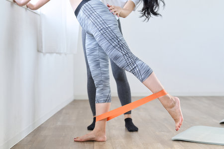 A woman doing lower body training using a resistance bandの写真素材