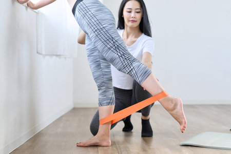 A woman doing lower body training using a resistance bandの写真素材