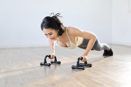 Woman doing push-ups using a push-up barの写真素材