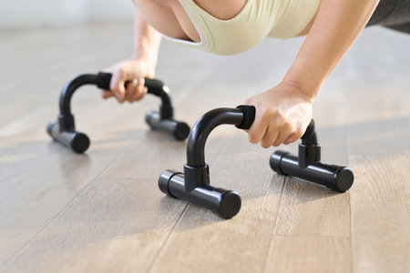 Woman doing push-ups using a push-up barの写真素材