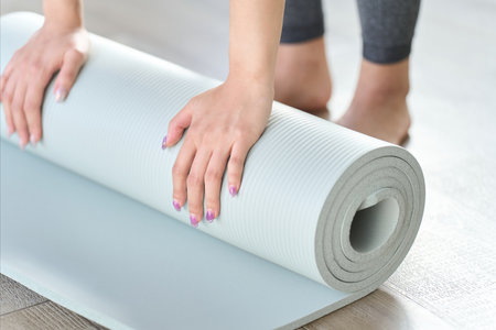 Hands of a woman spreading out a yoga matの写真素材