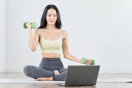 A woman doing muscle training while watching a videoの写真素材