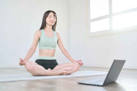A woman taking online yoga lessonsの写真素材