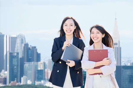 Two businesswomen walking in an office districtの写真素材