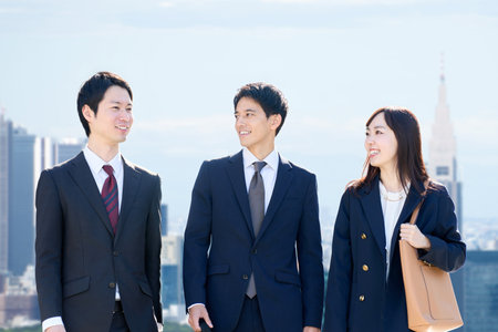 Three business people walking in an office districtの写真素材