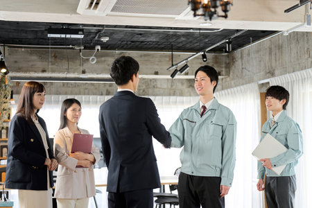 Businessman and worker shaking hands in the officeの写真素材