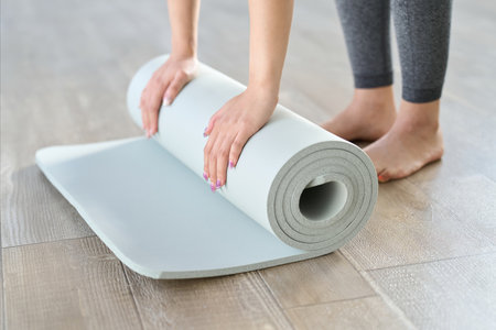 Hands of a woman spreading out a yoga matの写真素材