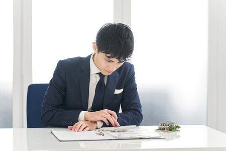 Businessman calculating money related to real estateの写真素材