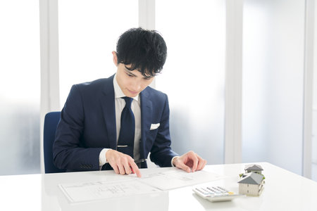 Businessman thinking about real estate floor planの写真素材
