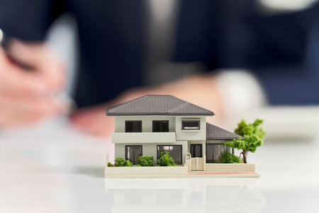 A miniature model of a house and a businessmanの写真素材