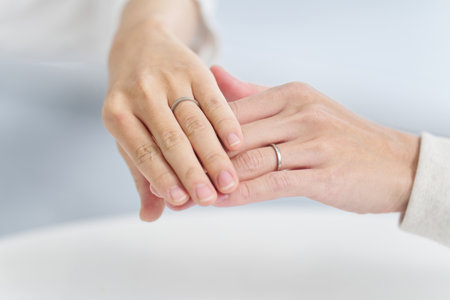 Couple holding hands and showing wedding ringsの写真素材