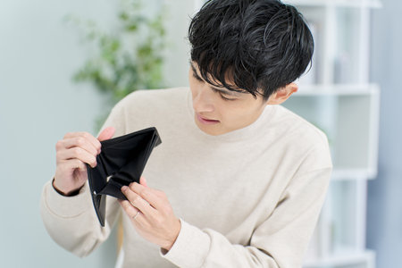 A man holding a wallet with no money in itの写真素材