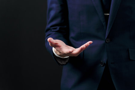 Businessman holding out his hand on black background