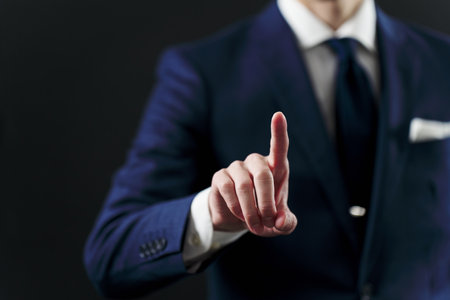 Businessman's hand pointing on black background