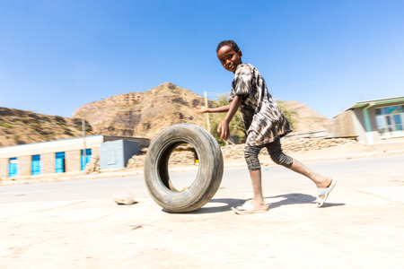 Mekelle, Ethiopia - NOVEMBER 30, 2017: children play with a tire around town.のeditorial素材