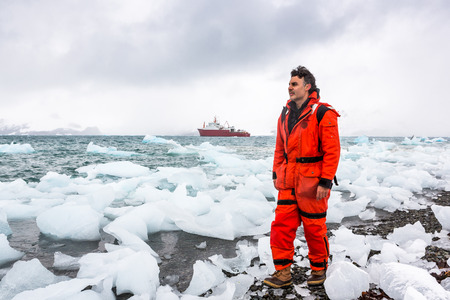 Man walks through ice and snow in Antarctica. Icebergs and everything frozen around you. Cold.の写真素材