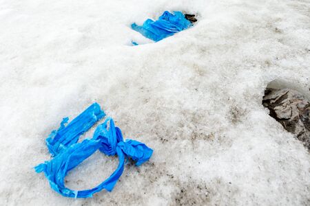 Garbage scattered over snowy mountain. Let's save the planet and recycle the excess garbage. Pollution Conceptの写真素材