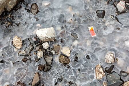 Garbage scattered over snowy mountain. Let's save the planet and recycle the excess garbage. Pollution Conceptの写真素材