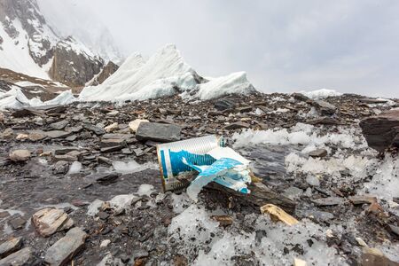 Garbage scattered over snowy mountain. Let's save the planet and recycle the excess garbage....