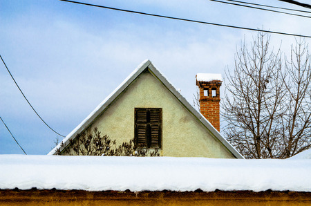 Village house with a chimney covered with snow.の写真素材