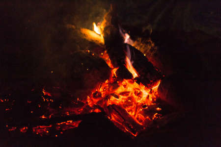 fire and hot coals in a campfire near the tentの写真素材