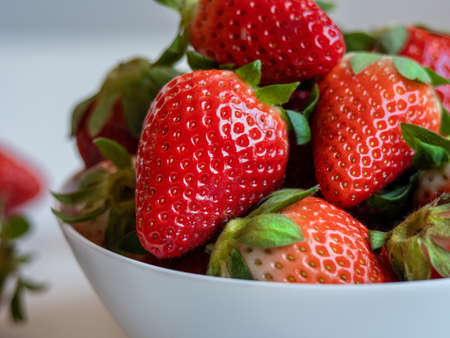 close up photo of a stawberry in a white bowl. delicious and healthy foodの写真素材
