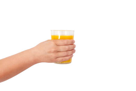photo of a glass with orange juice in a womans hand on a light backgroundの写真素材