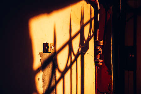 the shadow of the lattice on the old wall in the bright rays of the setting sun.の写真素材