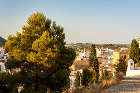 the old town from the hill surrounded by fields, trees and mountainsの写真素材
