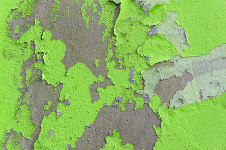 grunge texture of an old wall with peeling bright green paintの写真素材