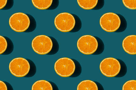 seamless pattern of ripe tasty orange cut in half on a deep blue backgroundの写真素材