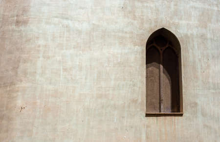 Concrete gray wall with arabic window in a shade covered with rusty fine meshの写真素材