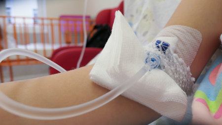 Young Girl on a Drip with Peripheral Venous Catheter in Hospital Bedの写真素材