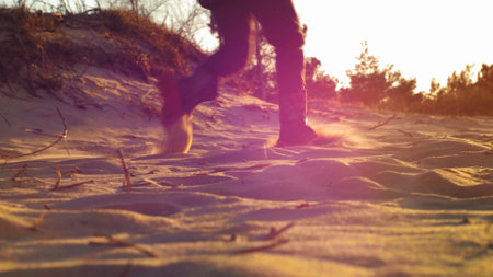 Young Girls Running on Sandy Sea Beach at Sunset with Lens Flareの写真素材