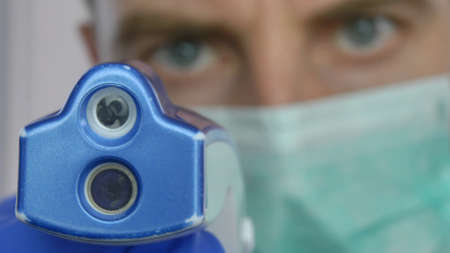 Doctor Using Non-Contact Thermometer on   Patient POV