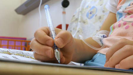 Young Girl on a Drip with Peripheral Venous Catheter in Hospital Bedの写真素材