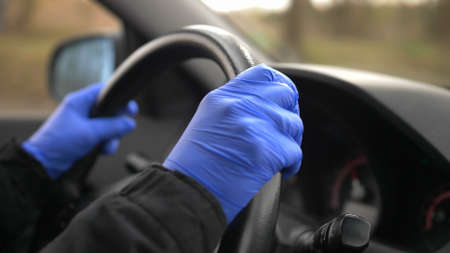 Driving a Car in Protective Surgical Gloves During Virus Outbreakの写真素材