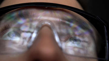 Dentist Analyzing Panoramic Dental X-Ray Image Reflecting in Protective Glassesの写真素材