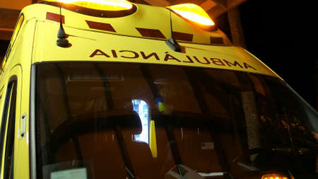 Ambulance with Flashing Siren Lights Parked By Emergency Departmentの写真素材