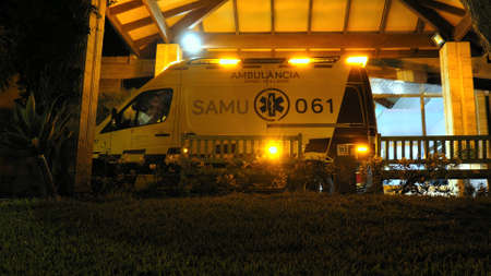 Ambulance with Flashing Siren Lights Parked By Emergency Departmentの写真素材