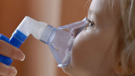 Sad Little Girl Making Inhalation in Inhalation Mask Slow Motionの写真素材