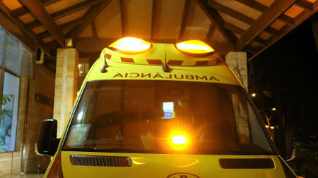 Ambulance with Flashing Siren Lights Parked By Emergency Departmentの写真素材