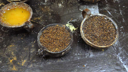 Close-up of Various Spices in Clay Pots with Wooden Spoonsの写真素材