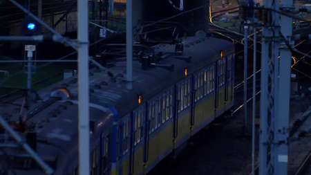 Passenger Suburban Train Arriving and Departing from Train Station at Night