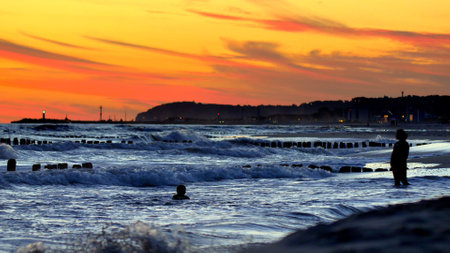 Stormy Sea Waves and Breakwater Poles at Baltic Sea after Sunset Slow Motionの写真素材