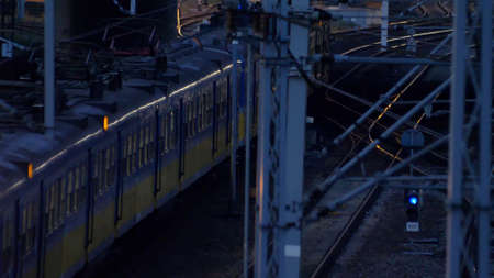 Passenger Suburban Train Arriving and Departing from Train Station at Nightの写真素材