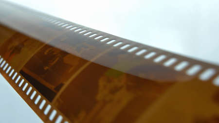 Watching Retro Pictures on Negative Plastic Film Strip Rollの写真素材