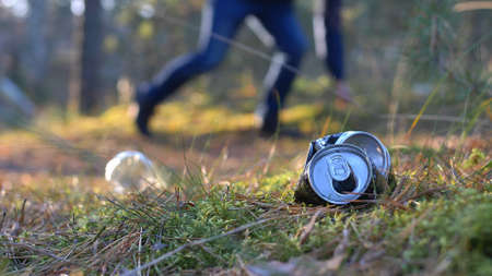 Picking Up Trash Cans and Bottles in Forest with Backlight Sunrise Light